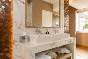 a bathroom with two sinks and a mirror at Olivier Leflaive Hôtel Restaurants in Puligny-Montrachet +45 photos