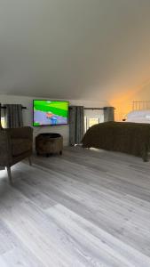 a living room with a bed and a flat screen tv at The Loft in Gwys Station