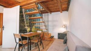a room with a table and chairs and a spiral staircase at Három Dió Vendégház in Nyim