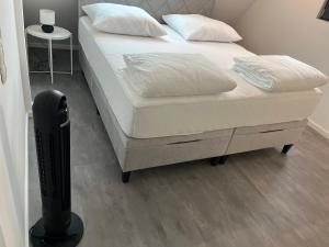 a bed with white sheets and pillows in a room at Moderne 4-Zimmer Wohnung in Wernau