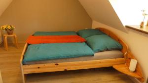 a wooden bed with four pillows in a room at Ferienwohnung Strandweg 1 in Wieck