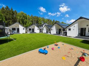 a house with a playground with toys in the yard at Biały Koral in Rusinowo