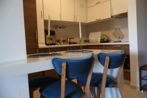 a kitchen with two blue chairs at a counter at Panorama Apartment in Mavrovo
