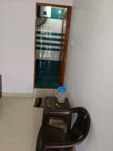 a chair and a table in a room with a mirror at Vinod Tourist Lodge in Gupta Kāshi