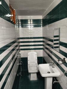 a bathroom with a white toilet and a sink at Vinod Tourist Lodge in Gupta Kāshi