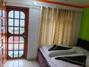 a small bedroom with a bed and a window at Vinod Tourist Lodge in Gupta Kāshi