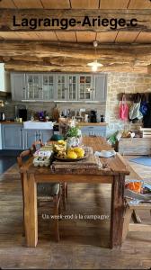 a kitchen with a wooden table with fruit on it at LaGrange-Ariege c in Massat +15 photos