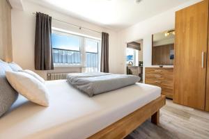 a bedroom with a large bed and a large window at Ferienwohnung Kircher in Obermaiselstein