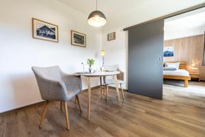 a dining room with a table and chairs and a bedroom at Ferienwohnung Kircher in Obermaiselstein