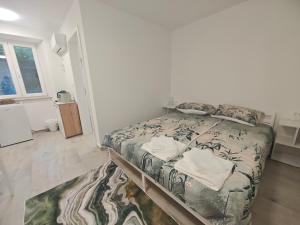 a bedroom with a bed and a rug at Sobe - Rooms NININ in Deskle