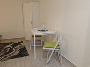 a small white table with a bottle and a chair at Sobe - Rooms NININ in Deskle +28 photos