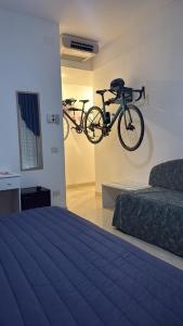 a bike hanging on a wall in a bedroom at Hotel Fortuna in Chioggia