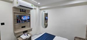a hospital room with a bed and a flat screen tv at Hotel HR Sky in Ahmedabad
