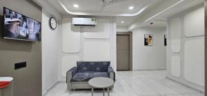 a waiting room with a chair and a tv at Hotel HR Sky in Ahmedabad +15 photos
