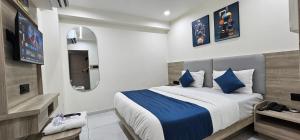 a bedroom with a large bed and a tv at Hotel HR Sky in Ahmedabad