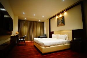 a hotel room with a bed and a desk and chair at Veerasa Hotel in Hanumāngarh