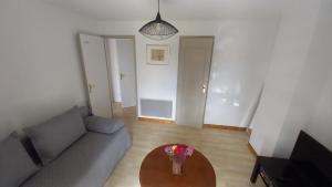 a living room with a couch and a table with flowers at Chambre d'hôtes Saumur-Champigny 2 personnes in Montreuil-Bellay