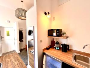 a kitchen with a sink and a microwave on a counter at Hideaway Suite in Ambleside