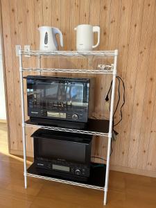 a microwave on a shelf with two microwaves on it at 小さなペンション Branchee in Kushimoto