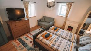 a living room with two beds and a tv and a chair at Három Dió Vendégház in Nyim