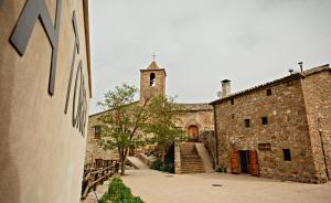 an old stone building with a clock tower and stairs at L'Antic ajuntament de la Torra in La Baronia de Rialb