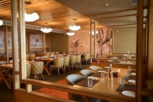 a restaurant with tables and chairs and a large mirror at Pride Elite Himmatnagar in Sonāsan