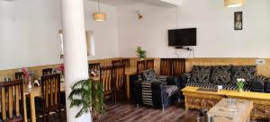 a living room with a couch and a tv at Hotel Namgyal Villa in Nubra