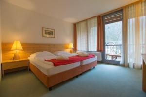 a bedroom with a bed and a large window at Hotel Bergkristall in Wildalpen +105 photos