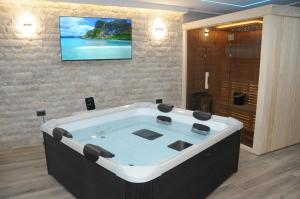 a bath tub in a room with a tv on the wall at Villa Lapis in Mostar +57 photos