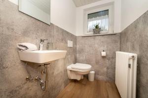 a bathroom with a sink and a toilet and a window at Ferienwohnung Kircher in Obermaiselstein +24 photos