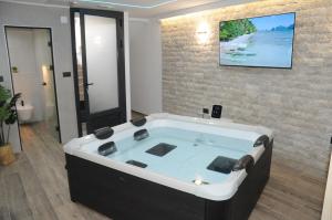 a bath tub in a room with a tv on a wall at Villa Lapis in Mostar