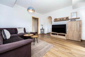 a living room with a couch and a flat screen tv at Ferienwohnung Kircher in Obermaiselstein