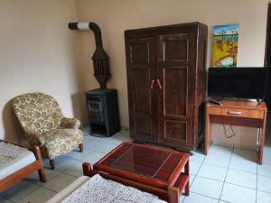 a living room with a tv and a chair at Smeštaj Mevlida in Belo Blato