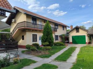 a house with a tree in the yard at Smeštaj Mevlida in Belo Blato