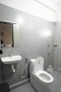 a bathroom with a toilet and a sink at Blue Pearl Residency in Trivandrum +5 photos