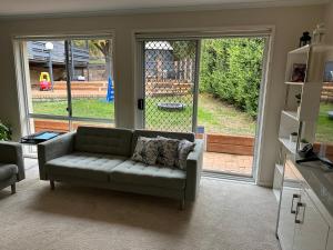 a living room with a couch in front of a sliding glass door at Cozy Curtin Cottage in Lyons