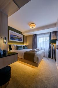 a hotel room with a large bed and a window at The Gable, Dingle in Dingle +23 photos