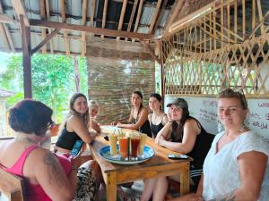 a group of women sitting around a table at Tetebatu Backpackers Base in Selong