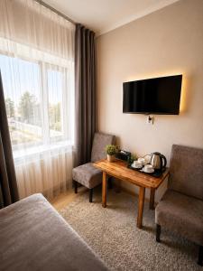 a hotel room with a table and a television at VIP Mini Hotel in Semey