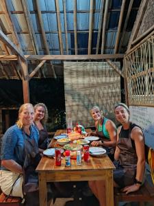 a group of people sitting around a wooden table at Tetebatu Backpackers Base in Selong +33 photos