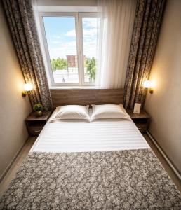 a bedroom with a large bed with a window at VIP Mini Hotel in Semey