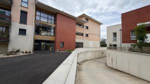 an empty street in front of a building at Loft Tolosa - Clim & Parking Privé Toulouse Nord in Rouffiac-Tolosan