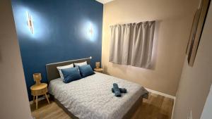 a small bedroom with a bed with blue pillows at Loft Tolosa - Clim & Parking Privé Toulouse Nord in Rouffiac-Tolosan