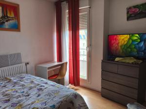 a bedroom with a bed and a dresser and a window at chambre double dans appartement in Le Kremlin-Bicêtre