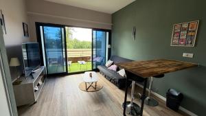 a living room with a table and a couch at Loft Tolosa - Clim & Parking Privé Toulouse Nord in Rouffiac-Tolosan