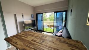 a living room with a table and a large window at Loft Tolosa - Clim & Parking Privé Toulouse Nord in Rouffiac-Tolosan