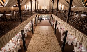 an aisle with tables and chairs in a banquet hall at Complex Turistic Le Baron Vatra Dornei in Vatra Dornei