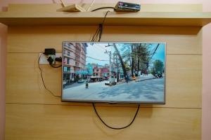 a tv hanging on a wall with a picture of a street at Rameshworam Hotel in Kathmandu