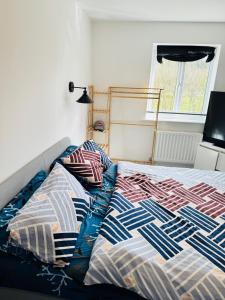 a bed with a comforter and pillows next to a window at Ansari House in Dummer