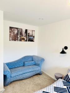 a blue couch in a white room with a picture at Ansari House in Dummer